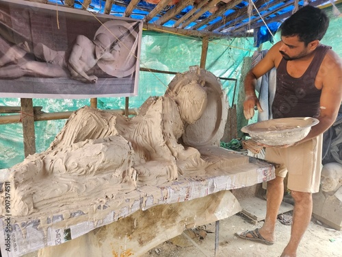 Indian Art, Closeup of sculptor or artist working on clay sculpture, making Gypsum mold of an Dying warrior (fallen Trojan warrior, Laomedon) clay Sculpture, craft or handmade.
 photo