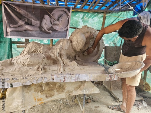 Indian Art, Closeup of sculptor or artist working on clay sculpture, making Gypsum mold of an Dying warrior (fallen Trojan warrior, Laomedon) clay Sculpture, craft or handmade.
 photo