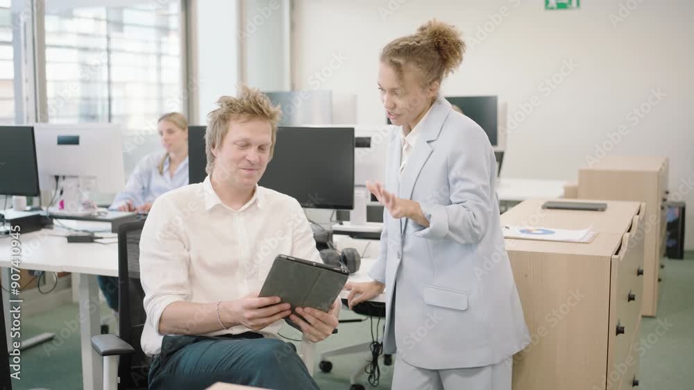 Business professionals engaging in a productive office meeting, discussing documents on a digital tablet. The setting is a modern, collaborative workspace with team members working together. Business professionals engaging in a productive office meeting, discussing documents on a digital tablet. The setting is a modern, collaborative workspace with team members working together.