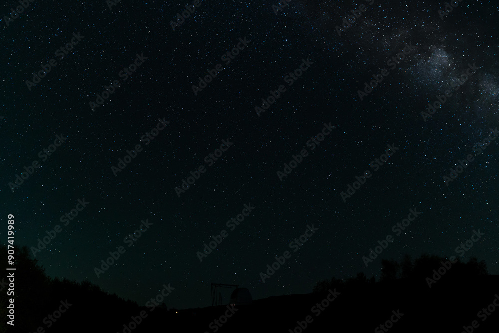 Starry night sky with Milky Way above an observatory silhouette. Starry night sky with Milky Way above an observatory silhouette.