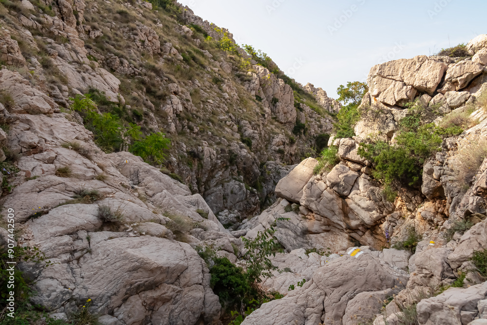 Narrow, rocky gorge Vrzenica (Žig Vrženica) cuts through rugged landscape in Baska, Krk Otok, Primorje-Gorski Kotar, Croatia. Scenic hiking trail through dramatic canyon leading to Vela and Mala Luka Narrow, rocky gorge Vrzenica (Žig Vrženica) cuts through rugged landscape in Baska, Krk Otok, Primorje-Gorski Kotar, Croatia. Scenic hiking trail through dramatic canyon leading to Vela and Mala Luka