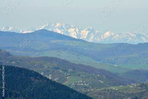 Obraz na płótnie A distant view from the hill of the high peaks of snow-capped mountains High Tatra in spring w salonie
