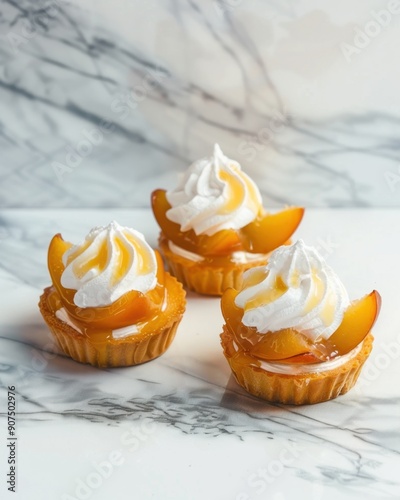 Three peach tarts with whipped cream on a marble surface. photo