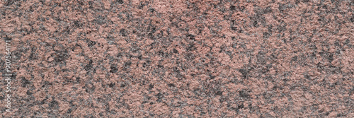 Granite texture. Natural pink granite with a grainy pattern. Stone background. Solid rough surface of rock. Durable construction and decoration material. Close-up.