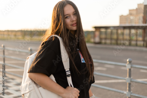 Teen girl with long hair at sunset in the city