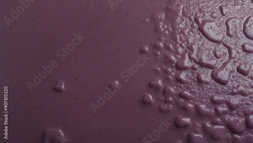 Smooth purple liquid surface with textured wet regions
