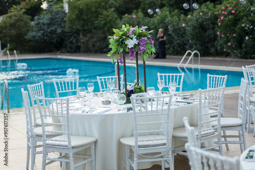 Elegant Outdoor Table Setting by the Pool with Colorful Floral Centerpieces