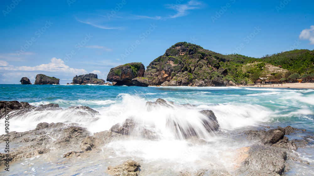 Obraz premium Water Splashes Rocks On The Beach