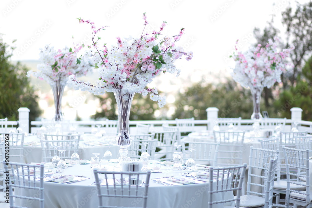 A minimalist and modern wedding table setting with a floral centerpiece and a view of the city. The table is set with clean lines and fresh greenery, creating a chic and contemporary look