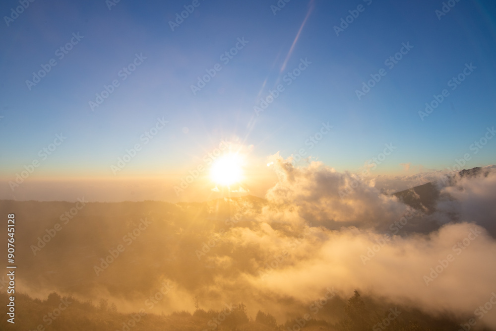 Fantastic sunrise on a volcano. View above and in the clouds of the rising sun and into the valley. Landscape shot on Mount Batur, Bali, Indonesia Fantastic sunrise on a volcano. View above and in the clouds of the rising sun and into the valley. Landscape shot on Mount Batur, Bali, Indonesia