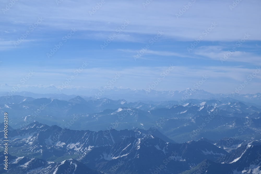 Obraz premium A stunning rock formation covered in snow, set against a clear blue sky with fluffy clouds in the background, creating a peaceful and breathtaking mountain landscape.