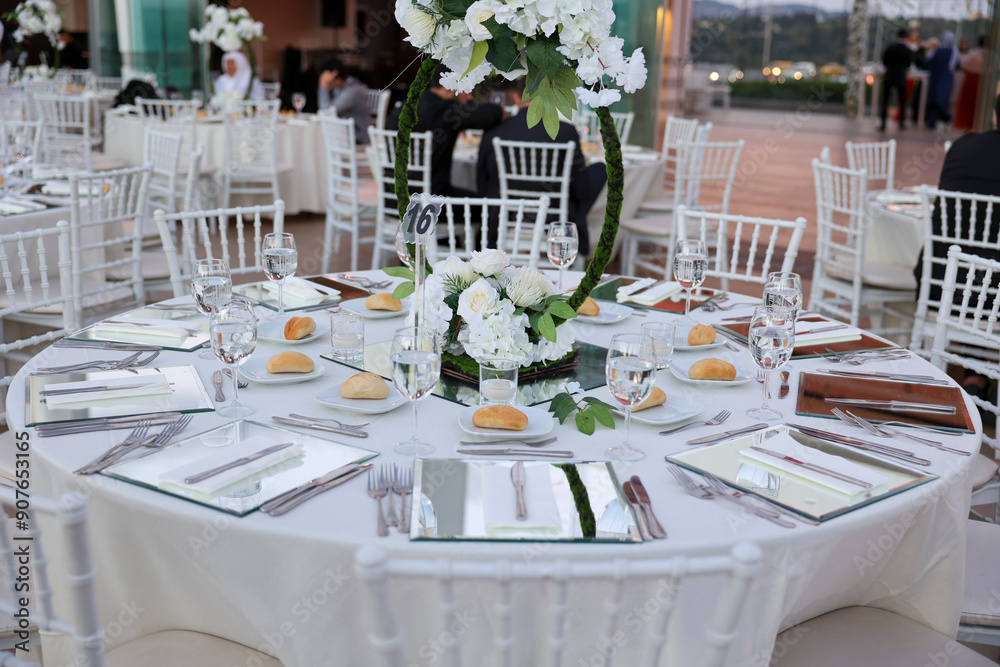 Elegant Indoor Wedding Reception with White Floral Centerpieces and Mirror Chargers
