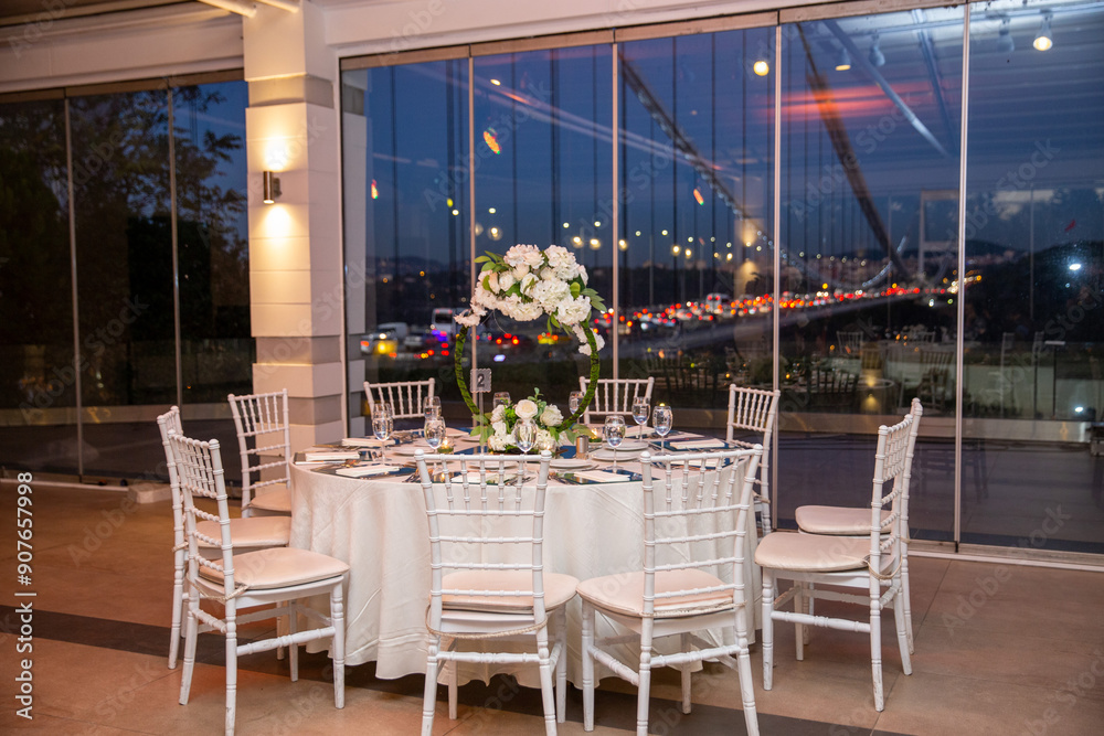 Charming Indoor Wedding Table Arrangement with White Decor and Night Cityscape