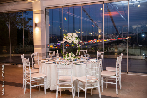 Obraz na płótnie Charming Indoor Wedding Table Arrangement with White Decor and Night Cityscape w salonie