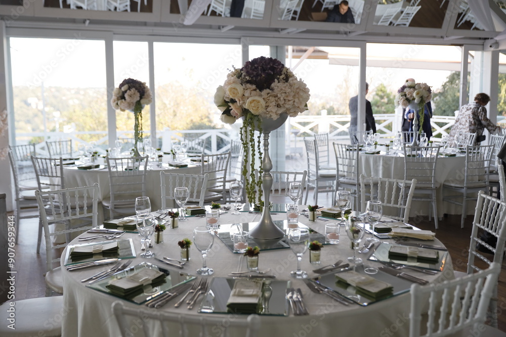 Elegant Wedding Venue with Floral Centerpieces and White Chairs