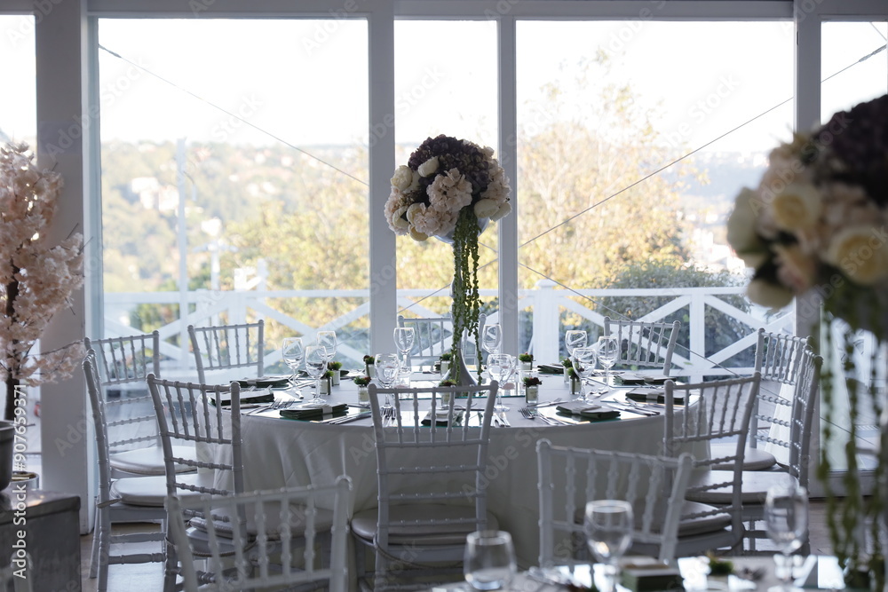 Elegant Wedding Venue with Floral Centerpieces and White Chairs