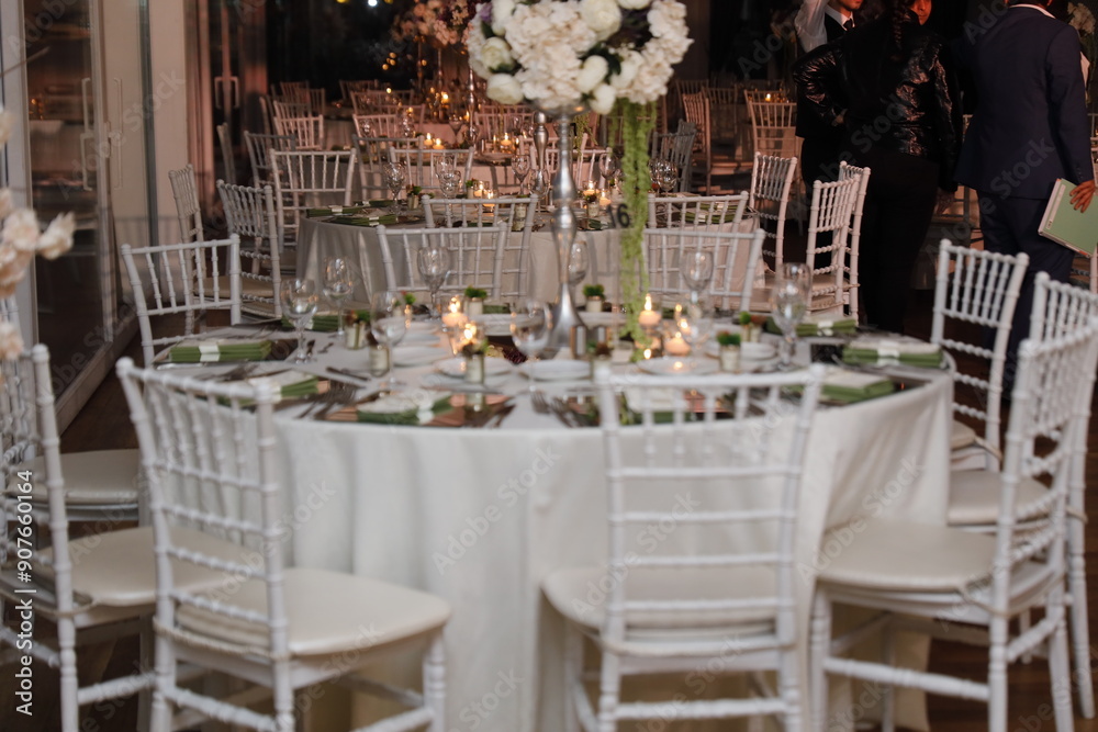 Elegant Wedding Venue with Floral Centerpieces and White Chairs
