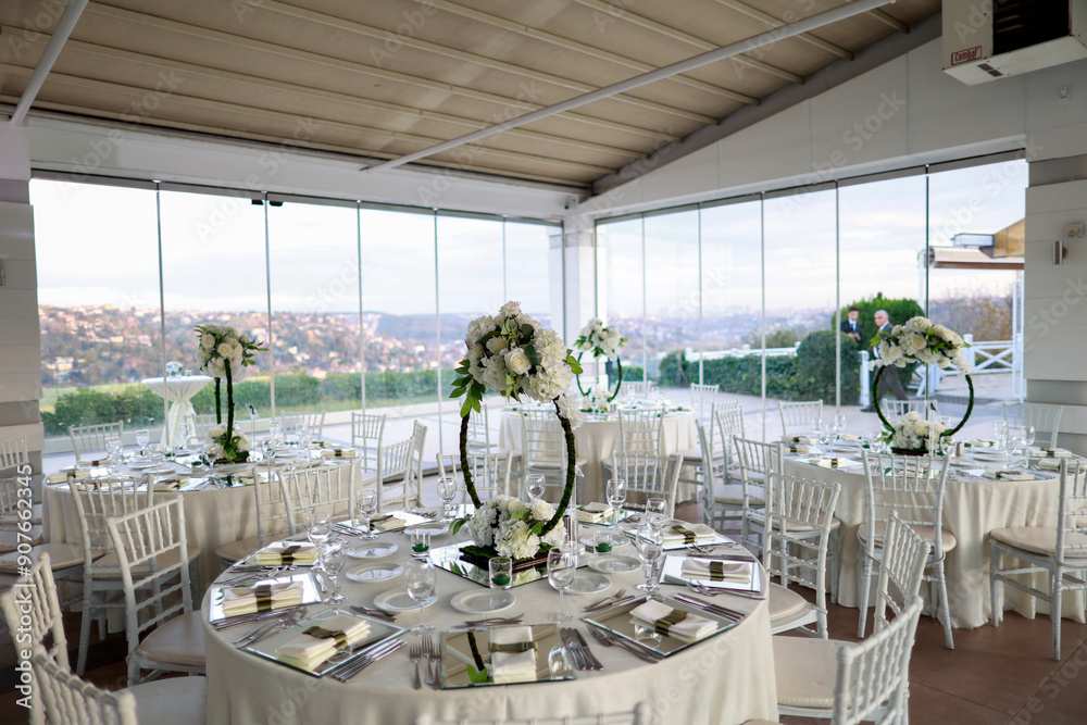 Elegant Wedding Venue with Floral Centerpieces and White Chairs