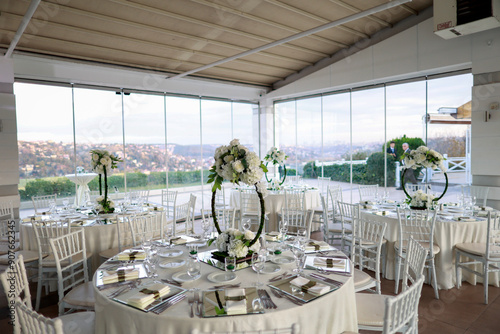 Elegant Wedding Venue with Floral Centerpieces and White Chairs