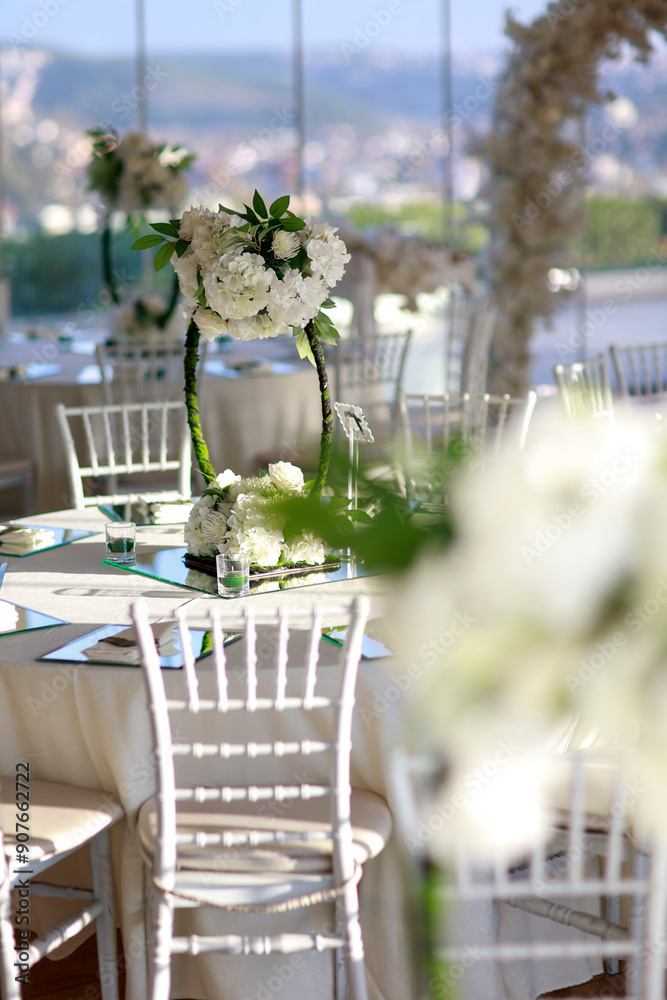 Elegant Wedding Venue with Floral Centerpieces and White Chairs