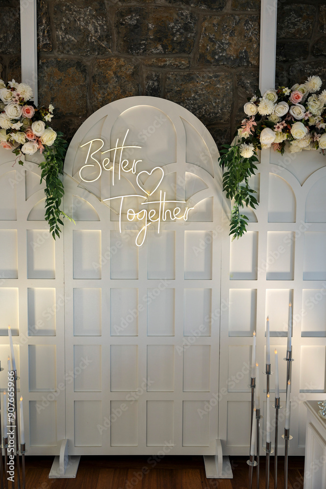 Refined Wedding Cake Presentation with Flowers and Lighting Inside Venue