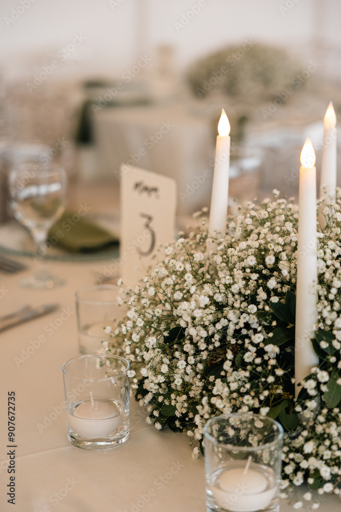 Romantic reception table with floral centerpiece and soft candlelight
