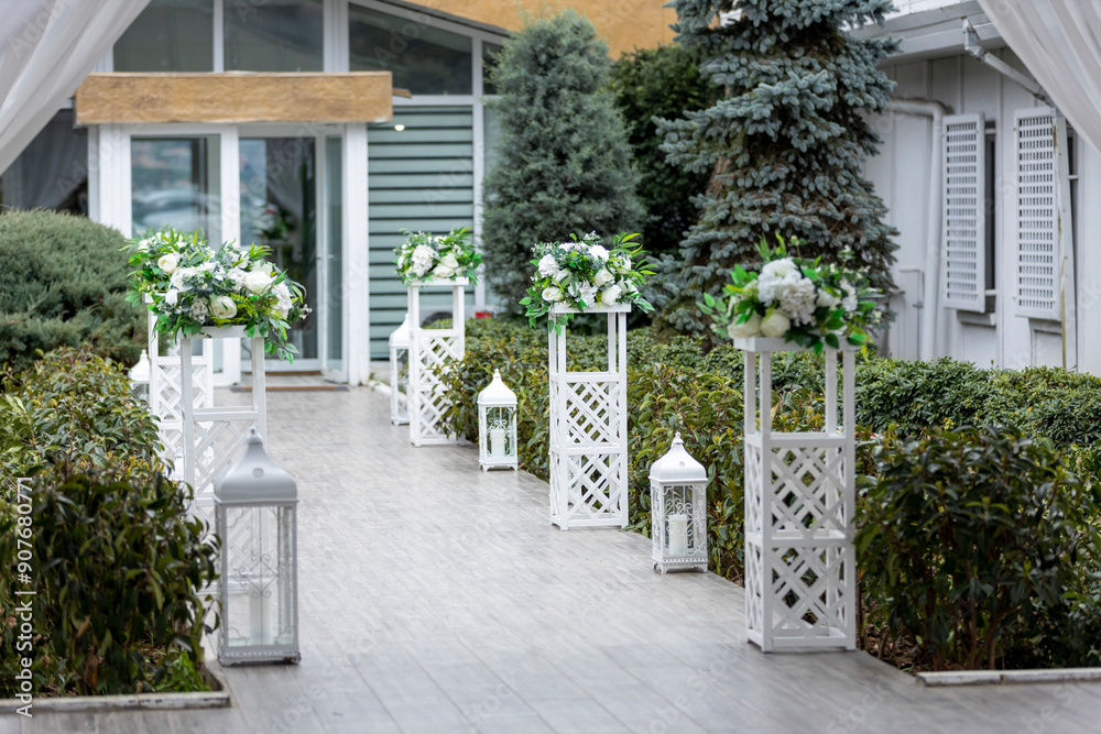 White Decorative Stands and Lanterns in Outdoor Venue for Romantic Wedding Ceremony