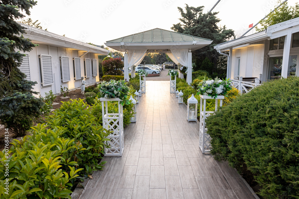 White Decorative Stands and Lanterns in Outdoor Venue for Romantic Wedding Ceremony