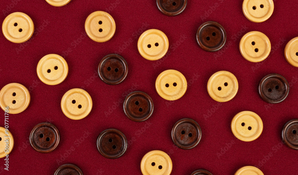 Wooden round buttons different color on a burgundy fabric Wooden round buttons different color on a burgundy fabric
