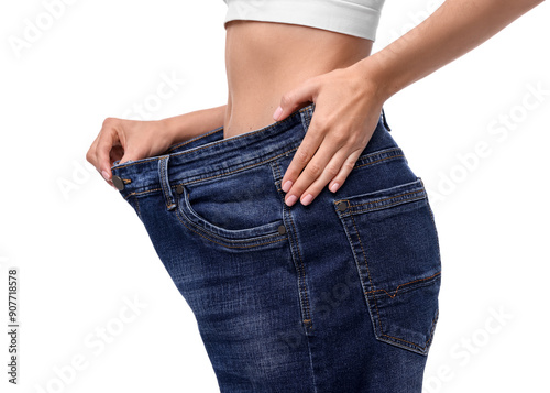 Fototapeta Naklejka Na Ścianę i Meble -  Diet and weight loss concept. Woman in big jeans showing her slim body on white background, closeup