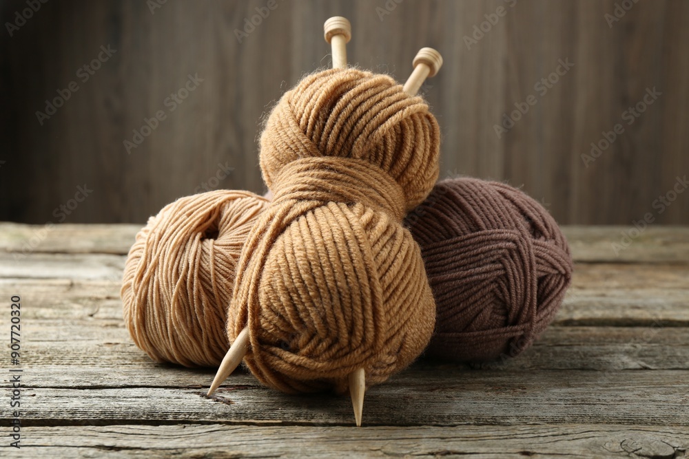 Skeins of soft yarn and knitting needles on wooden table Skeins of soft yarn and knitting needles on wooden table