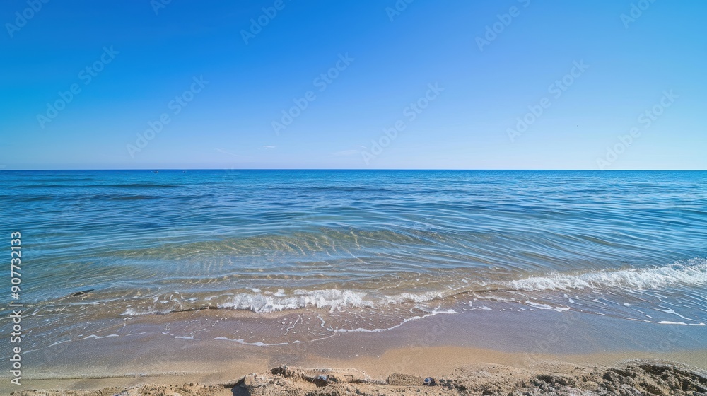 Serene blue water meeting the shore on a sunny day, offering a sense of tranquility and peace Serene blue water meeting the shore on a sunny day, offering a sense of tranquility and peace