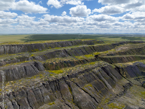 The terraced slopes of a coal mine in the steppe.