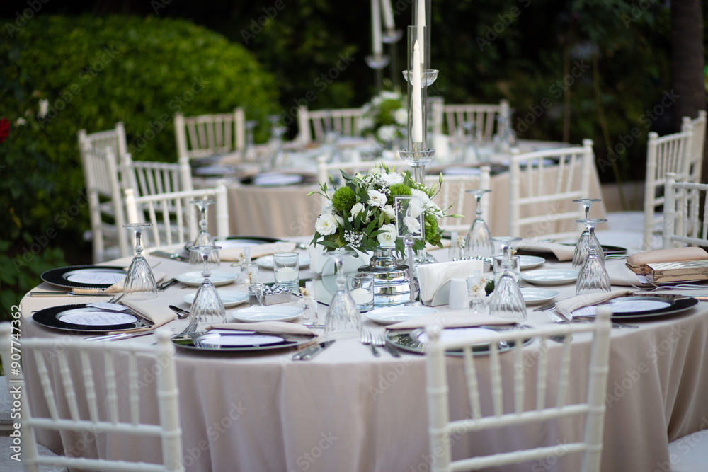 Refined Wedding Reception Table with White Centerpiece and Candlelight Outdoors