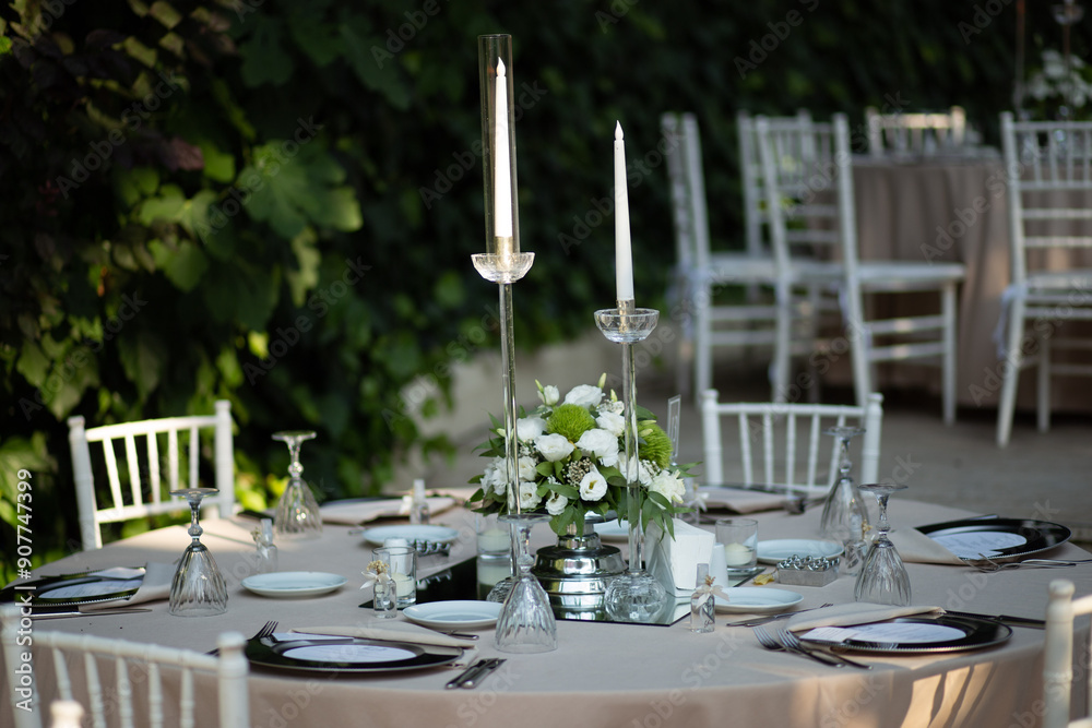 Elegantly Set Wedding Table with White Flowers and Candles at Outdoor Reception