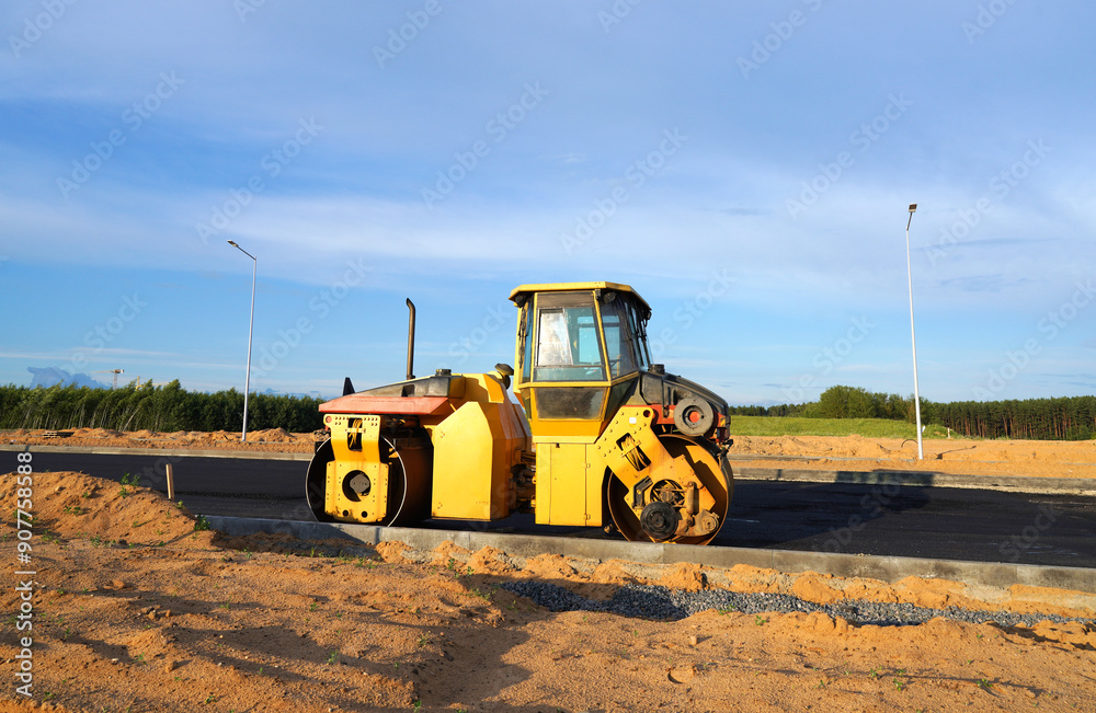 Obraz premium Asphalting paving repairing works. Vibrator compactor machine on roadworks on city street. Asphalt road roller on road construction. Road Construction Equipment. Vibration roller on Asphalting.