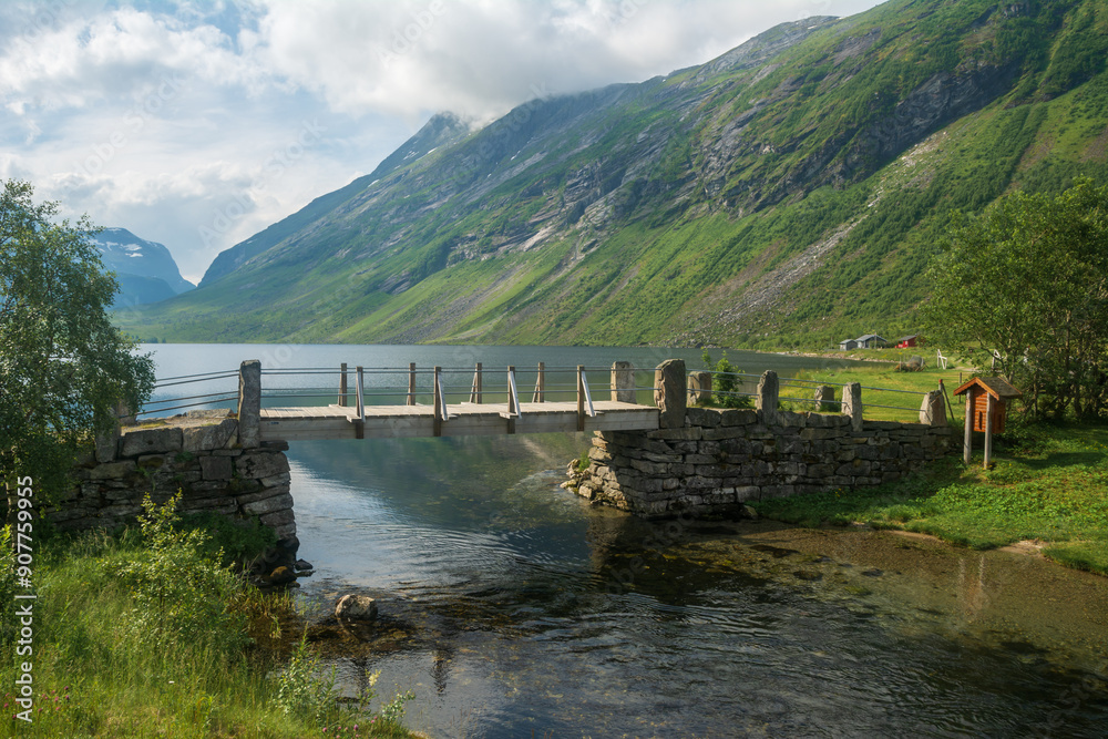 Summer landscape with an old stone bridge across the small river in rural Norway. Summer landscape with an old stone bridge across the small river in rural Norway.