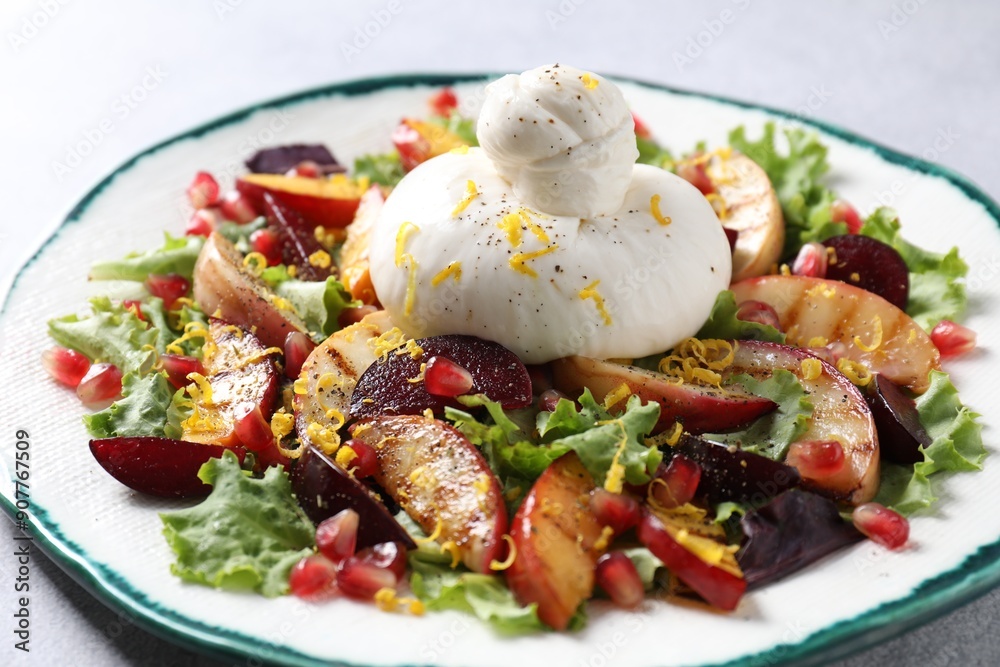 Plate with fresh burrata salad on grey table, closeup Plate with fresh burrata salad on grey table, closeup