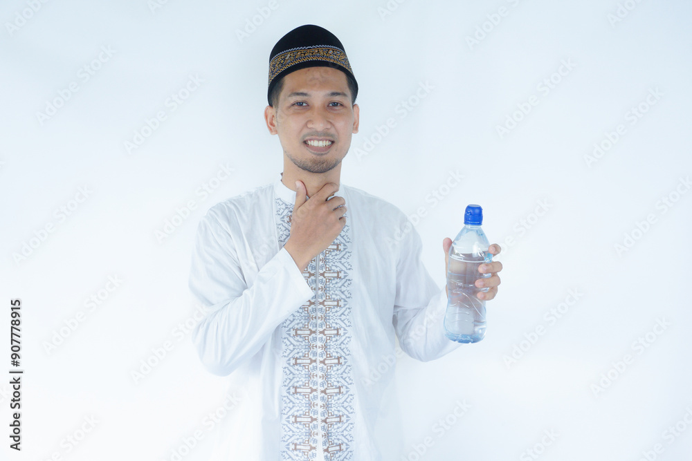 Moslem Asian man showing relieved expression after drink a water Moslem Asian man showing relieved expression after drink a water