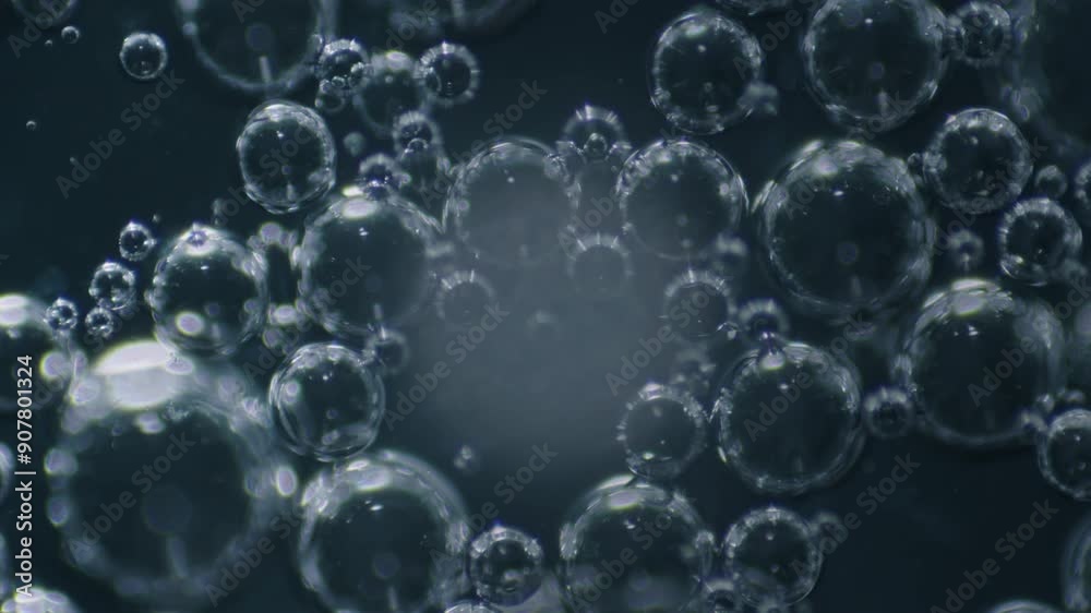 Extreme no people macro of drop of saliva with air bubbles being rotated on specimen table under microscope in laboratory in clockwise motion, on black background Extreme no people macro of drop of saliva with air bubbles being rotated on specimen table under microscope in laboratory in clockwise motion, on black background