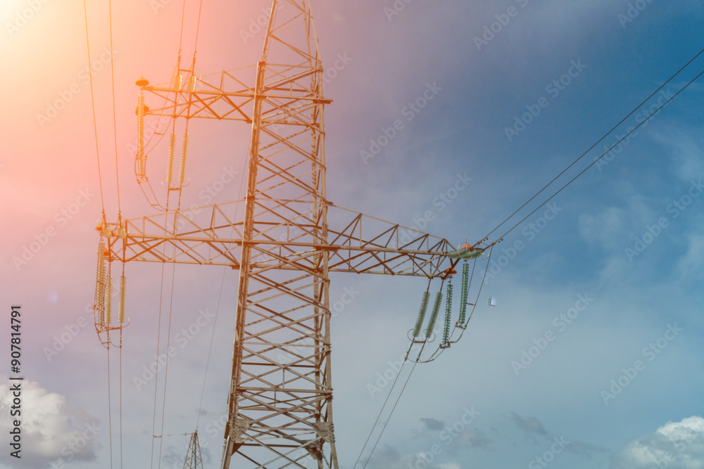 Fototapeta premium High voltage towers with sky background. Power line support with wires for electricity transmission. High voltage grid tower with wire cable at distribution station. Energy industry, energy saving