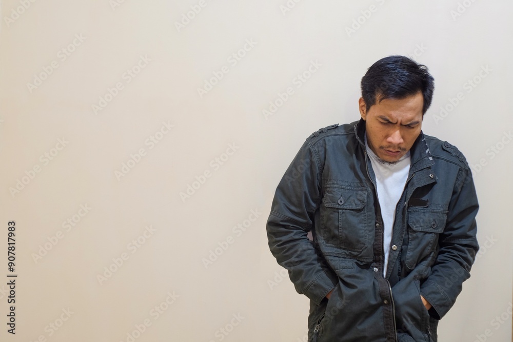 Portrait of A Southeast Asian man wearing a jacket and grimacing because he is very cold, trying to get warm. Portrait of A Southeast Asian man wearing a jacket and grimacing because he is very cold, trying to get warm.