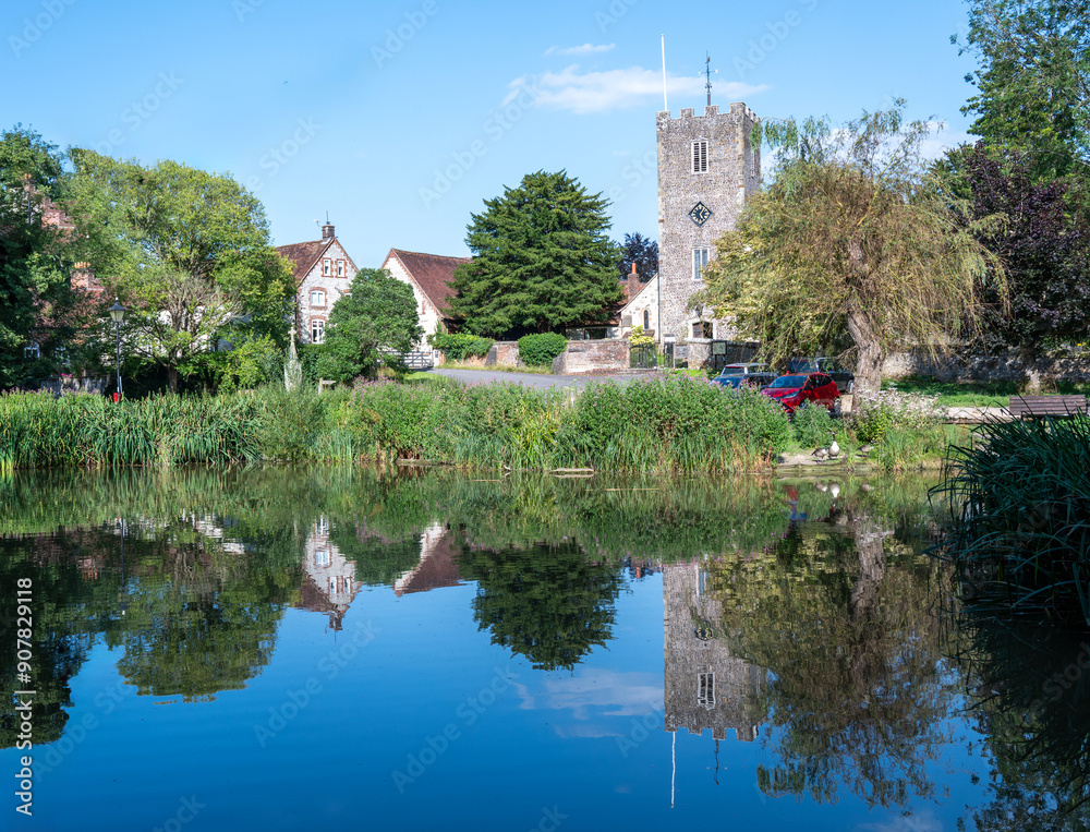 A reflection of St Mary's church tower in Buriton pond on a bright summer afternoon. A reflection of St Mary's church tower in Buriton pond on a bright summer afternoon.