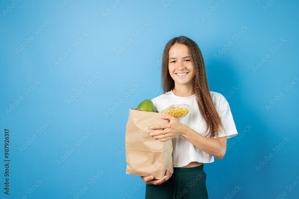 Teenage student with a bag of groceries, person ordering food online, happy girl with delivery,young female in supermarket, smiling teen buying vegetables Teenage student with a bag of groceries, person ordering food online, happy girl with delivery,young female in supermarket, smiling teen buying vegetables