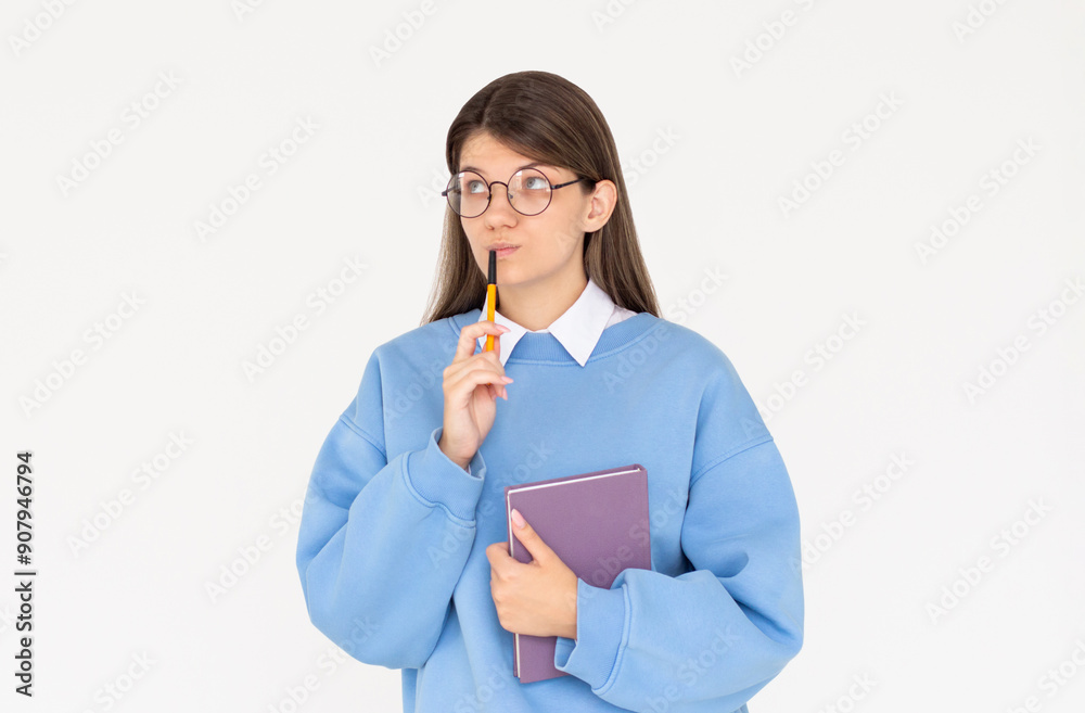 Cute woman thinking about smth with notepad. Young brunette student girl is thoughtful with pen in hand on white background Cute woman thinking about smth with notepad. Young brunette student girl is thoughtful with pen in hand on white background