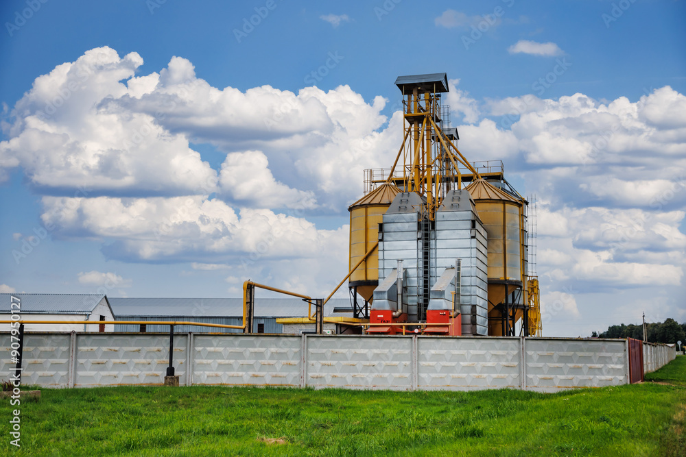modern granary elevator with silver silos on agro-processing and manufacturing plant for processing drying cleaning and storage of agricultural products, flour, cereals and grain. modern granary elevator with silver silos on agro-processing and manufacturing plant for processing drying cleaning and storage of agricultural products, flour, cereals and grain.