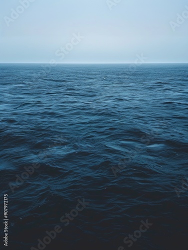 Wallpaper Mural The ocean is calm and peaceful, with no visible waves or ripples. The sky is a light blue color, and the water is a deep shade of blue. The scene is serene and tranquil, with a sense of stillness Torontodigital.ca