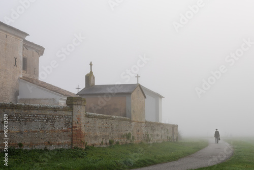 Chiesa in una giornata nebbiosa nelle campagne del Friuli, Italia. Esterno del cimitero annesso alla chiesa.
