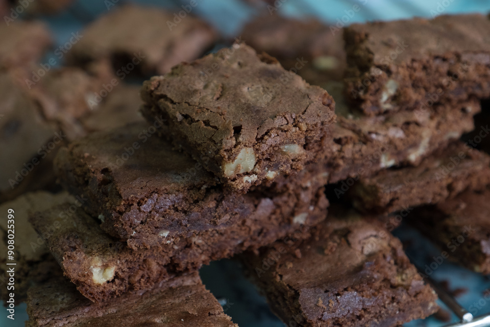 Delicious homemade chocolate brownies with nuts stacked on a cooling rack. Delicious homemade chocolate brownies with nuts stacked on a cooling rack.