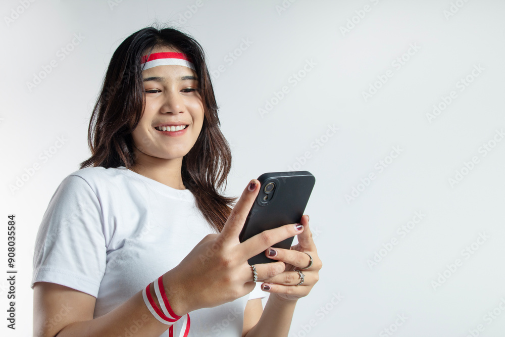 photo of Asian woman smiling while playing with smartphone, taken from below directly on the woman's face in a white t-shirt, concept of Indonesian independence photo of Asian woman smiling while playing with smartphone, taken from below directly on the woman's face in a white t-shirt, concept of Indonesian independence